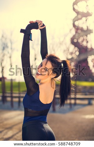 Side view of happy sport woman stretching outdoor at London