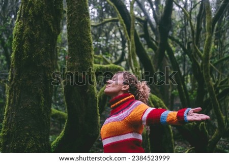 Side view of happy tourist enjoying green forest woods and trees opening arms and outstretching with smile expression and serene wellbeing. Healthy nature lifestyle people outdoors leisure adventure