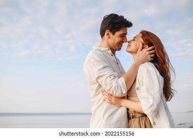 Side view happy young couple two friends family man woman 20s wearing casual clothes hug each other going to kiss at sunrise over sea beach ocean outdoor exotic seaside in summer day sunset evening