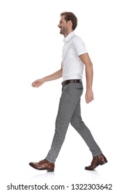 side view of a happy young man walking forward on white background