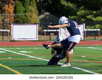 Side view of a high school football player kicking a field goal during a game. - Shutterstock ID 2241201181