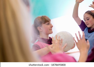 Side View Of A High School Student Playing Volleyball During A Gym Class.