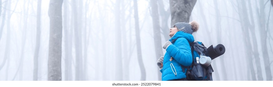 Side view of a hiker woman hiking in the mountains breathing fresh air in a foggy forest in winter -  Winter travel concept - Powered by Shutterstock