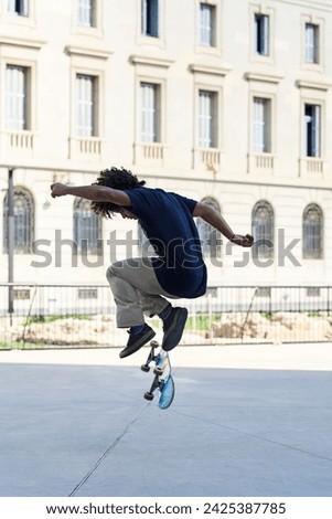 Side view of hipster doing skateboarding trick in the street.
