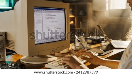Side View Of Hispanic Female Engineering Student Writing Academic Thesis On Old Desktop Computer In Retro Garage. Future Engineer Focused On Innovative Project For University Of Technology In Nineties