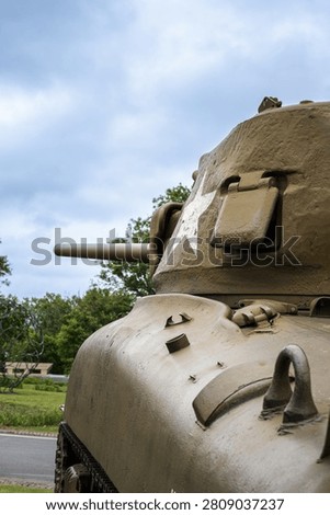 Side view of a historical World War II American Sherman tank with a white star insignia at the Normandy 44 Omaha Beach Museum in France.