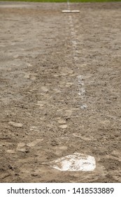 Side View Of Home Plate Up The First Base Line, On A Dirt Baseball Infield, With Space For Text On The Top