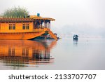 Side view of a houseboat in serene waters of Nigeen lake, Jammu and Kashmir. Nigeen lake is connected with Dal lake and is a popular tourist destination with many houseboats for tourist accomodation. 