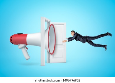 Side View Of Huge Megaphone In Open Doorway Knocking Businessman Off His Feet With Soundwave And Making Him Grab At Door So As Not To Fly Away. Speak Up Policy. Breaking News. Social Media.