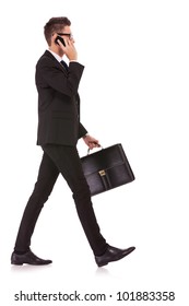 Side View Of A Hurrying Business Man Talking On The Mobile Phone On White Background