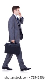 Side View Of A Hurrying Business Man Talking On The Mobile Phone