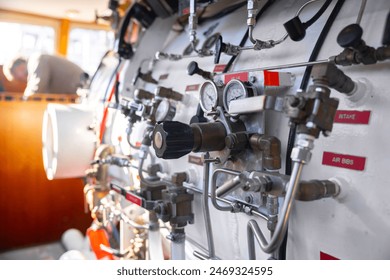 Side view of hyperbaric chamber with valves and pipes closeup