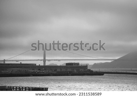 Side view of the iconic Golden Gate Bridge covered with fog.