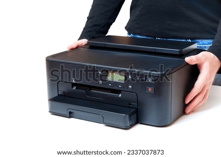 Side view of an inkjet printer held in the hands of a person against a clean white background. Versatility and portability of modern printing.