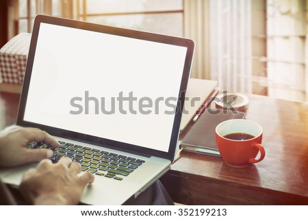 side view of the laptop is on the work table in a conner office with morning light.