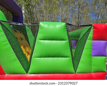 A side view of a large obstacle course bouncy castle.