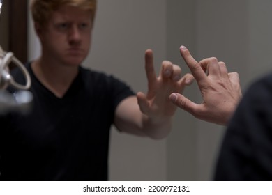 Side View Of Lonely And Sad Caucasian Man Wearing Black T-shirt And Reaching Out To His Reflection In The Mirror. Selective Focus. Blurred Face. Mental Health Theme.