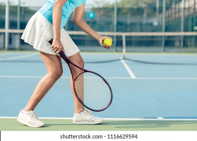 Side View Low Section Of A Young Woman Wearing White Skirt And Tennis Shoes While Serving During Professional Match