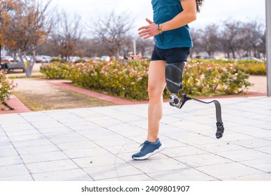 Side view of the lower part of a disabled person with prosthetic leg running in an urban park - Powered by Shutterstock