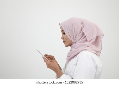 Side View Malay Woman With Tudung Using Smart Phone On The White Background