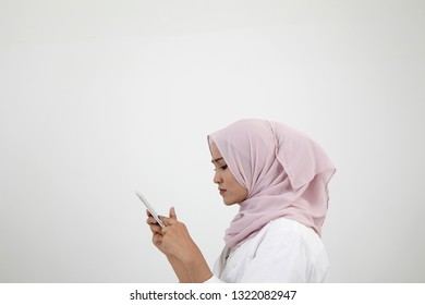 Side View Malay Woman With Tudung Using Smart Phone On The White Background
