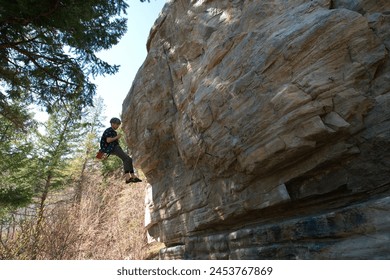 Side view of male climber being lowered off rock face - Powered by Shutterstock