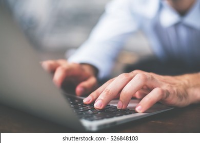 Side view of male hands typing on laptop keyboard - Shutterstock ID 526848103