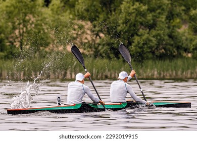 side view male kayakers on kayak double in kayaking competition race, water splashes from paddles