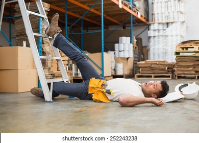 Side view of male worker lying on the floor in warehouse
