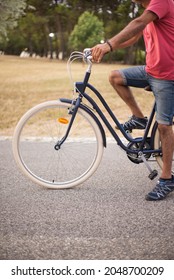 Side View Of Man With Bicycle In Autumn Park. Man Riding Bike Along Country Road. Sport And Leisure Concept