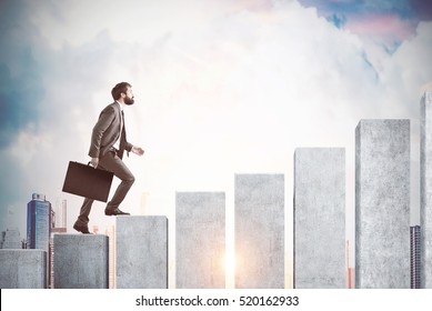 Side view of a man climbing the concrete stairs made in the shape of a graph. Cloudy sky and city are in the background. Concept of success and achieving your goal. Mock up. Toned image