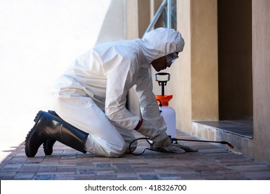 Side View Of A Man Doing Pest Control At Home