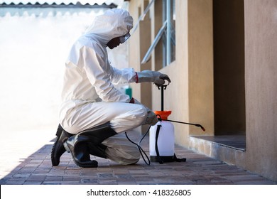 Side View Of A Man Doing Pest Control At Home