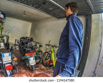 Side View Of A Man Entering A Garage Through A Tilting Door