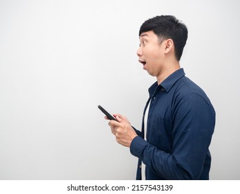 Side view man holding mobile phone excited emotion looking at copy space
