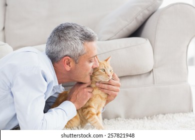 Side View Of Man Kissing Cat By Sofa At Home