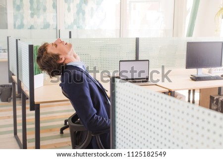 Side view of man leaning back in chair with eyes closed and masturbating at work dreaming of erotic scenes