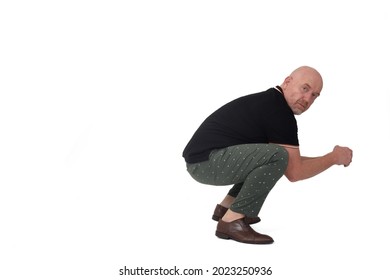 side view of a man looking at camera and sitting squatting on white background