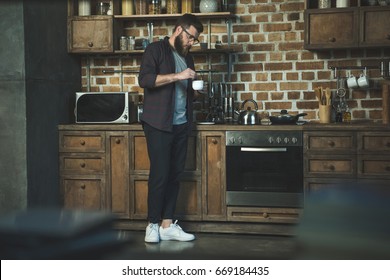 Side View Of Man Making Cup Of Coffee On Kitchen At Home