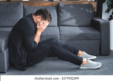 Side View Of Man With Panic Attack Crying In Apartment 