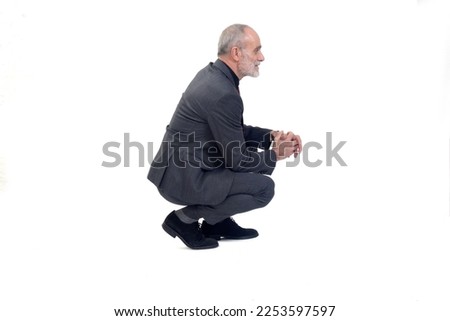 side  view of a man with suit squatting on white background