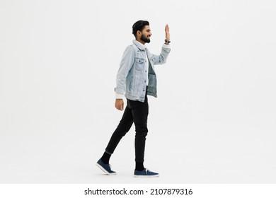 Side View Of Man Waving Walking On White Studio Background