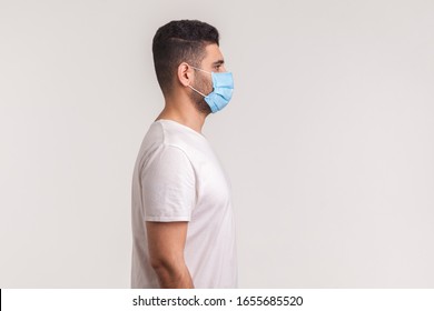 Side view of man wearing hygienic mask to prevent infection, respiratory illnesses such as flu, 2019-nCoV. indoor shot isolated, copy space for advertise about coronavirus, Covid-19prevention awarenes