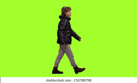 Side View Of A Man In Winter Clothes Walks On Green Screen Background, Chroma Key