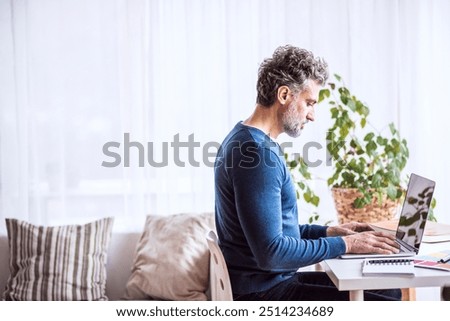 Side view of man working on computer from home. Telecommuting, homeoffice for handsome man. with copy space.