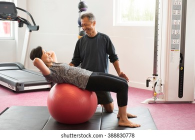 Side view of mature couple using exercise ball