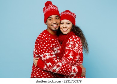 Side view merry young lovely smiling couple two man woman wear red Christmas sweater Santa hat posing hug look camera isolated on plain pastel light blue background Happy New Year 2023 holiday concept - Powered by Shutterstock