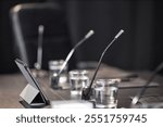 Side view of microphone and tablet computer placed on meeting table in conference room of local administration, copy space