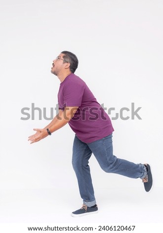Side view of a middle aged man trying to catch something falling down while running. Looking up anticipating where it will land. Whole body photo isolated on white background.
