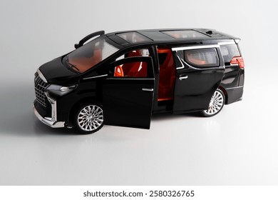 Side view of  a miniature of a black Multi-Purpose Vehicle (MPV) car on white background